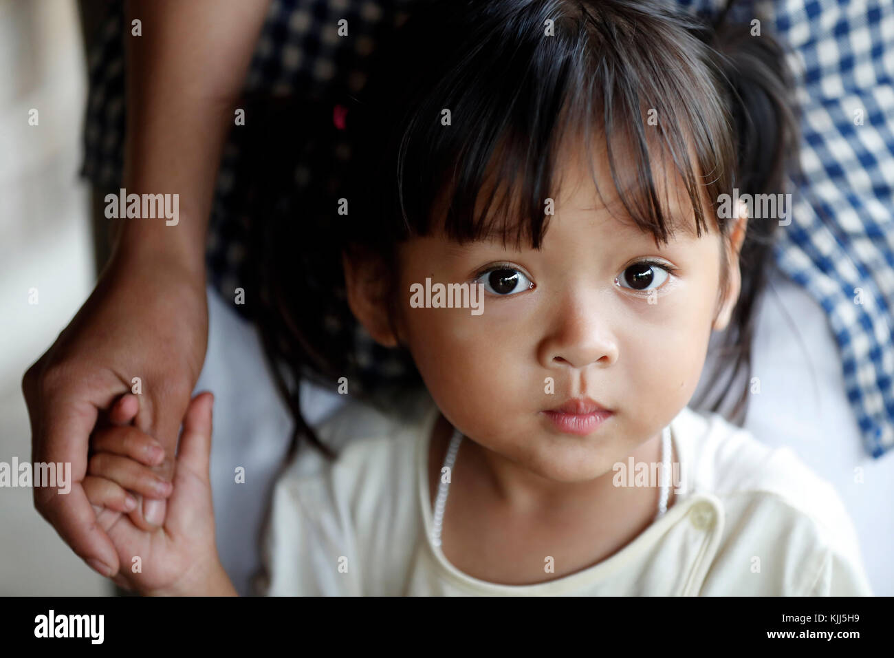 Ba Na (Bahnar) groupe ethnique. Jeune fille hording la main de sa mère. Portrait. Kon Tum. Le Vietnam. Banque D'Images