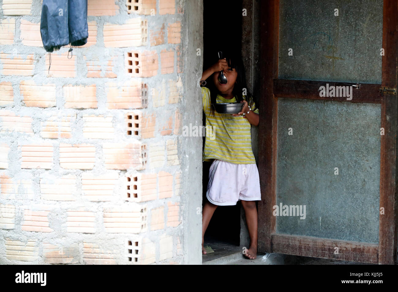 Ba Na (Bahnar) groupe ethnique. Young Girl eating. Kon Tum. Le Vietnam. Banque D'Images