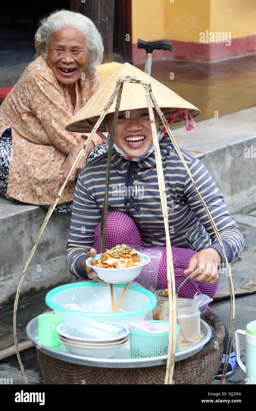 Vietnamese woman selling nourriture dans la rue. Hoi An. Le Vietnam. Banque D'Images