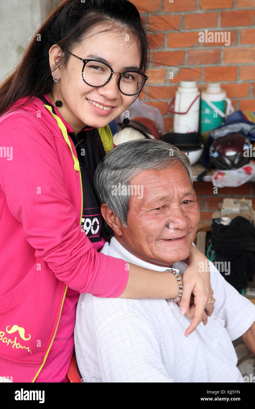 Girf avec son grand-père à la maison. Thay Ninh. Le Vietnam. Banque D'Images