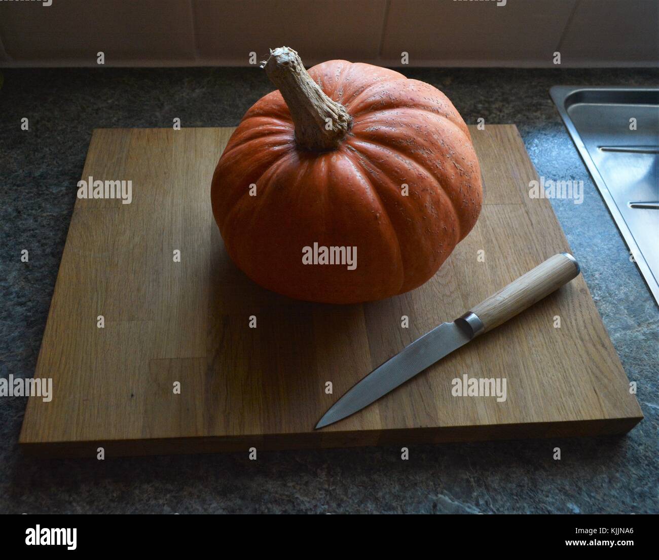 Pumpkin sur planche à découper en bambou avec couteau de cuisine sur la poignée haut Banque D'Images