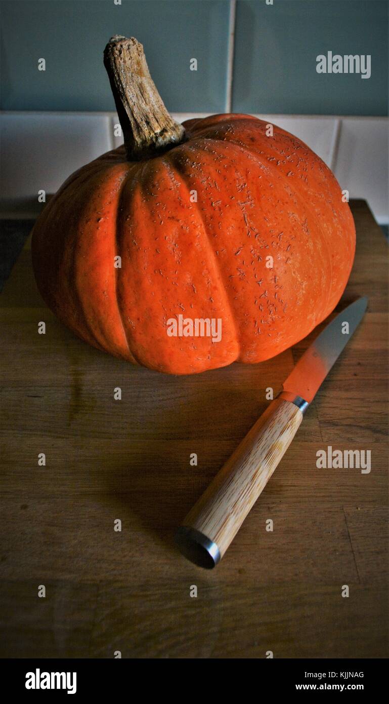 Pumpkin sur planche à découper en bambou avec couteau de cuisine sur la poignée haut Banque D'Images