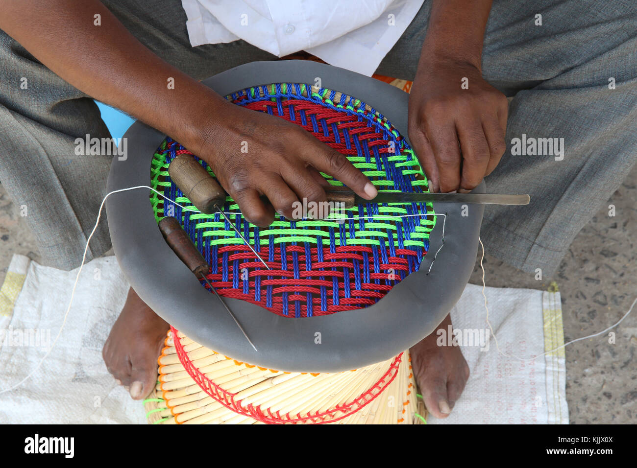Artisan du Rajasthan faire un 'muddha', petit tabouret de roseaux et de chaîne de couleur. L'Inde. Banque D'Images