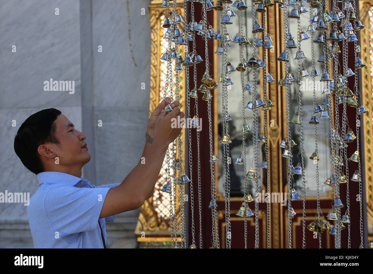 Fidèles offrant un petit Wat Trahimit dans bell, Bangkok. La Thaïlande. Banque D'Images