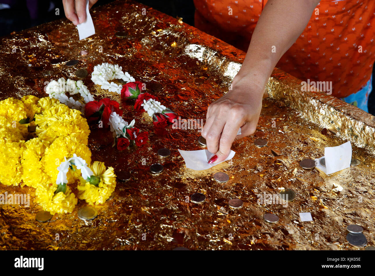 Wat Khao Pansa célébration dans Ampharam, Hua Hin. Fidèles offrant des feuilles d'or. La Thaïlande. Banque D'Images