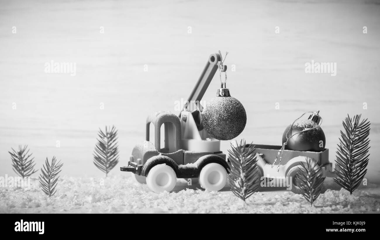 Un petit jouet voiture est une grue. Nouvel An et Noël arrière-plan. Les arbres de Noël à partir de la mini du vrai sapin. Père Noël en papier. Un vide pour une postcar Banque D'Images