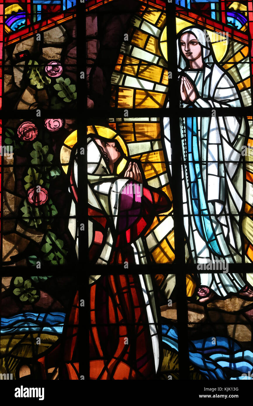La cathédrale de Dalat. Vitrail. Notre Dame de Lourdes : une image représentant Marie apparaissant sur la grotte, en face de Bernadette Soubirous. Dalat. Banque D'Images
