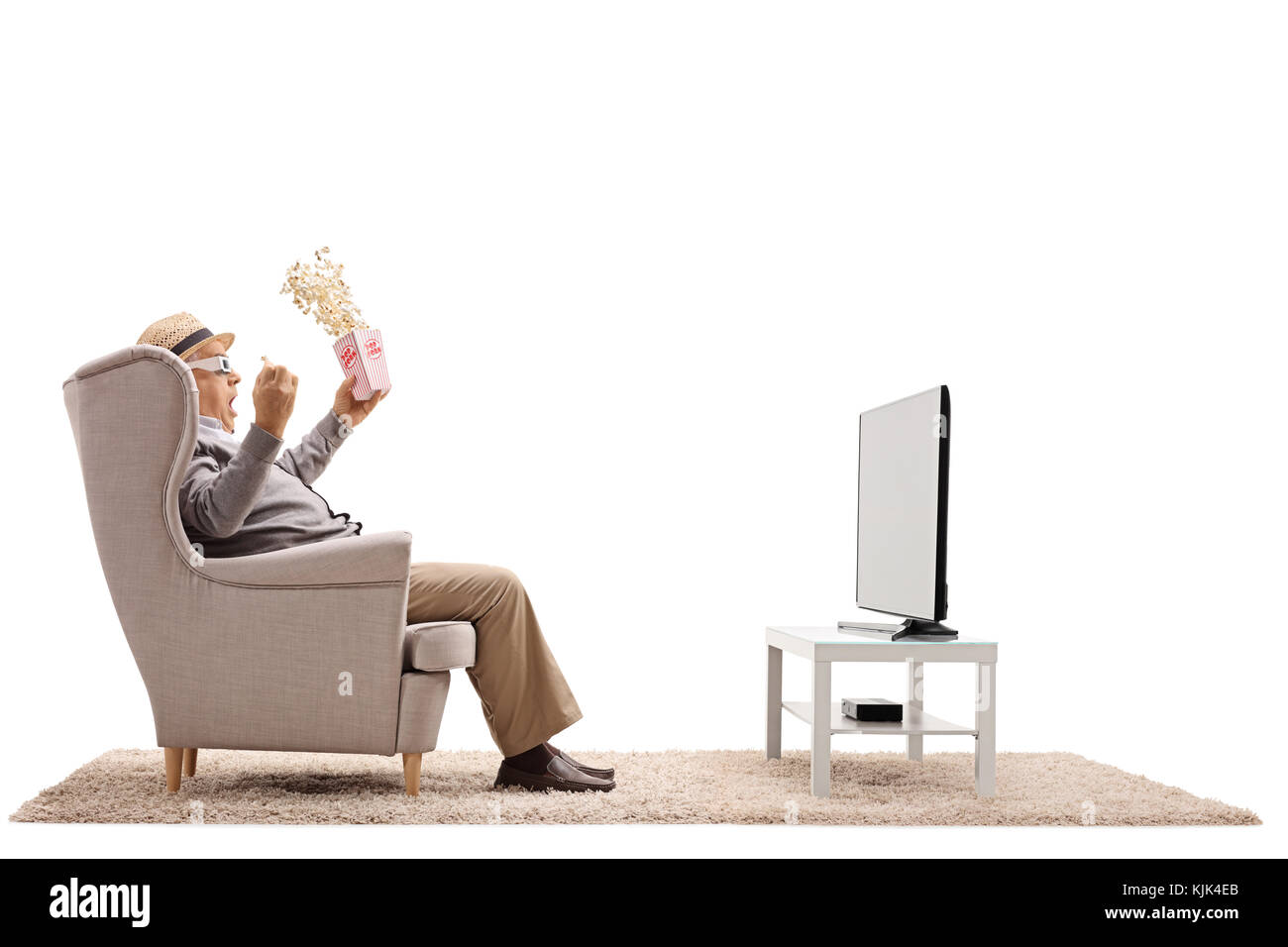 Terrifié homme mûr avec pop-corn et les lunettes 3d assis dans un fauteuil et regarder la télévision isolé sur fond blanc Banque D'Images