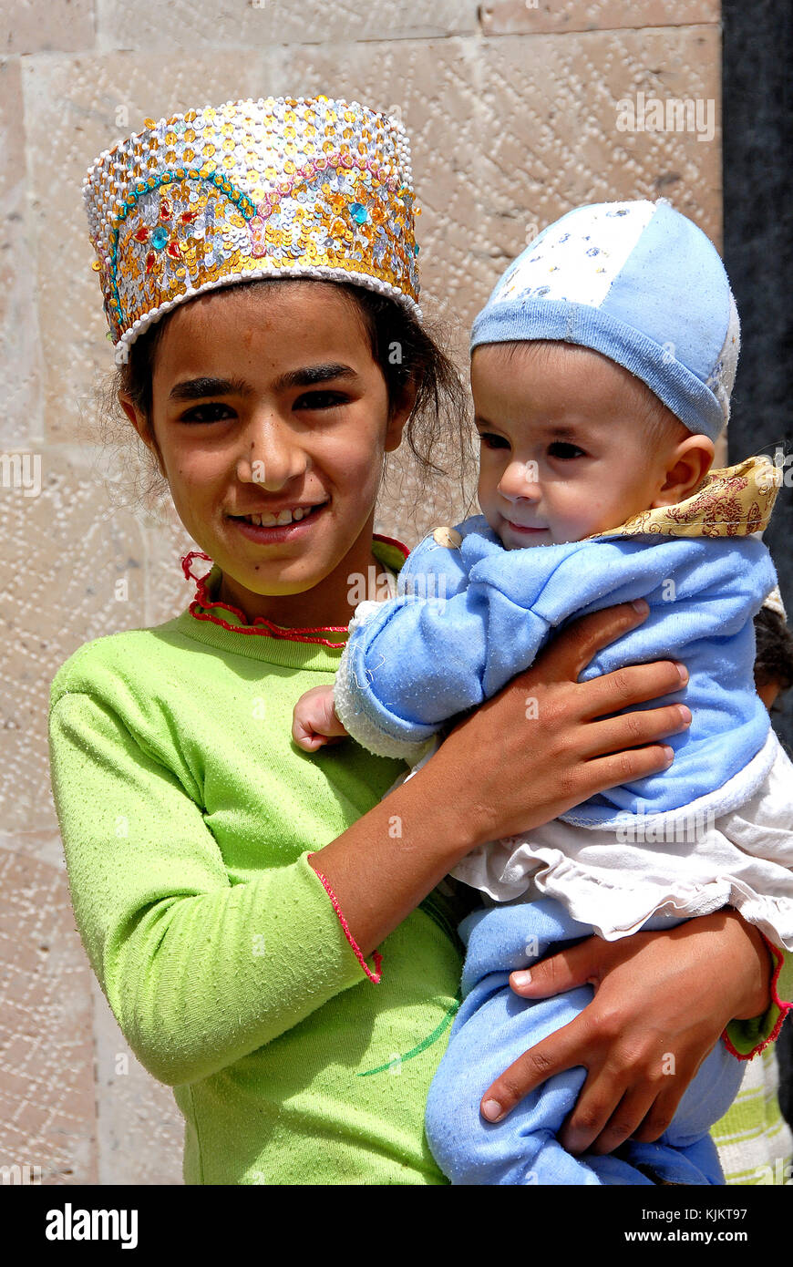 Fille yéménite portant son jeune frère. Banque D'Images