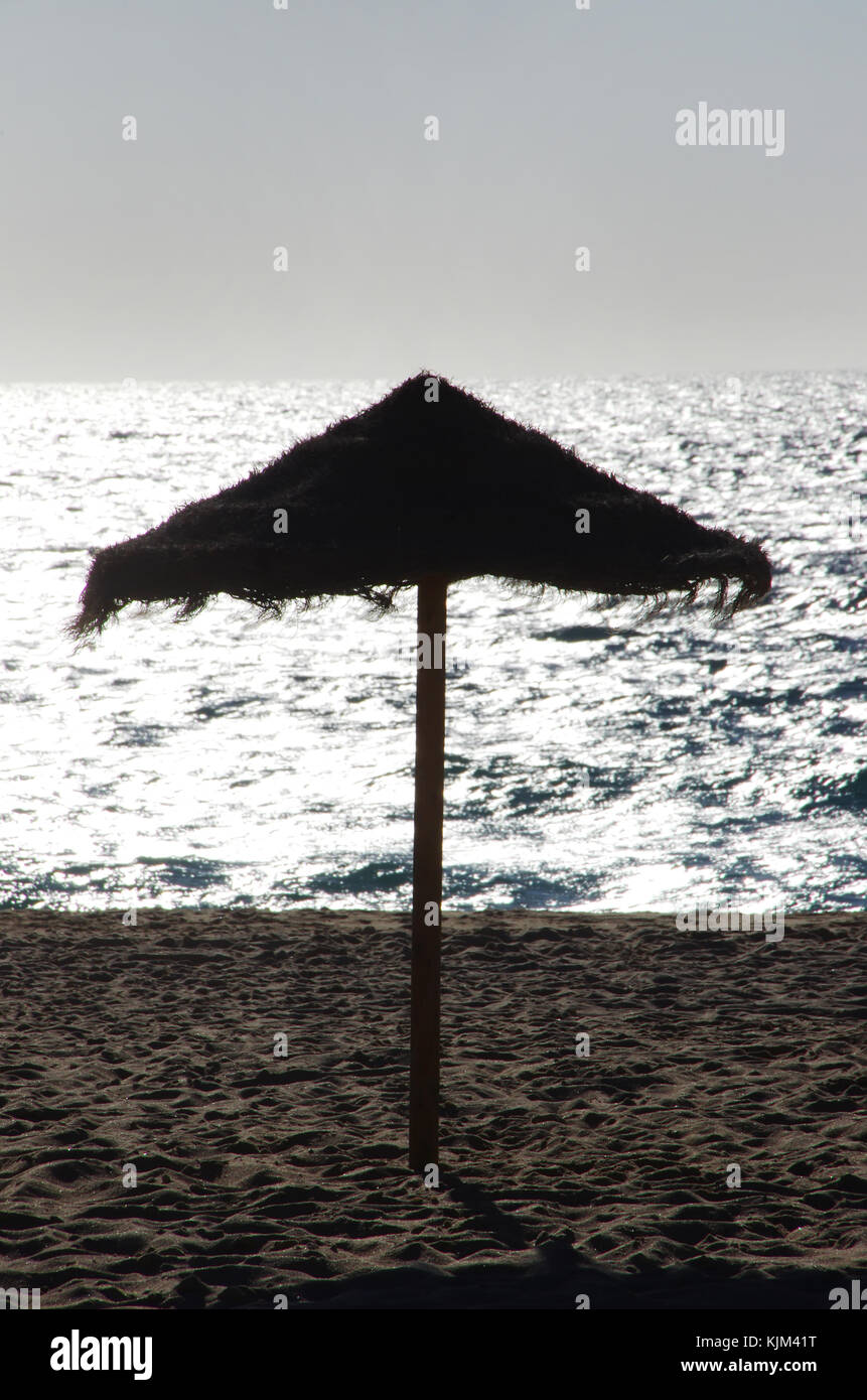 Parasol silhouette dans le coucher du soleil à plage portugaise Banque D'Images