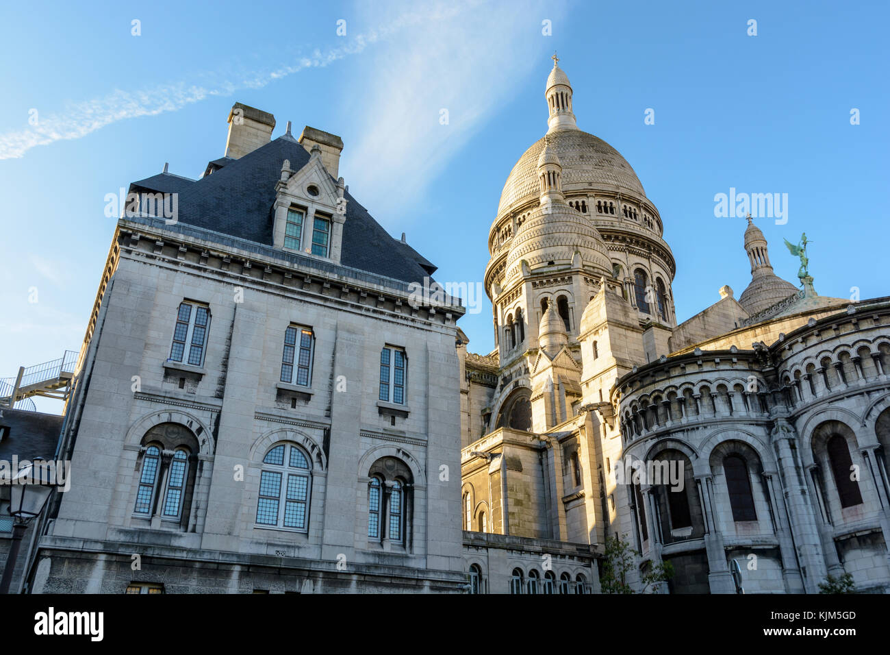 Vue arrière de la coupole de la Basilique du Sacré Coeur de Paris au lever du soleil avec le gîte de la basilique à l'avant-plan. Banque D'Images