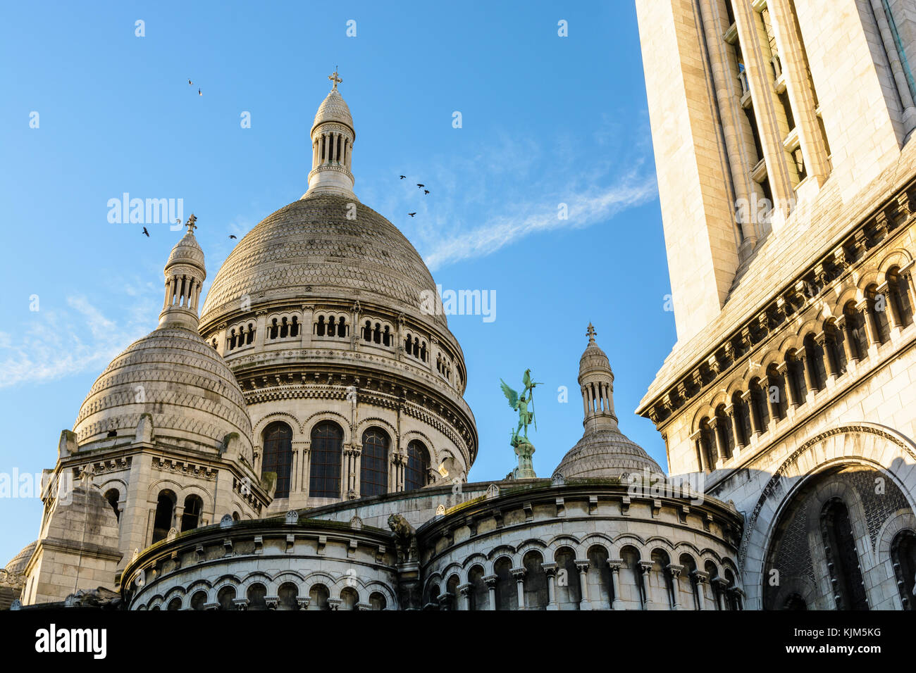 Vue arrière de la coupole de la Basilique du Sacré Coeur de Paris au lever du soleil avec le clocher carré à l'avant-plan. Banque D'Images