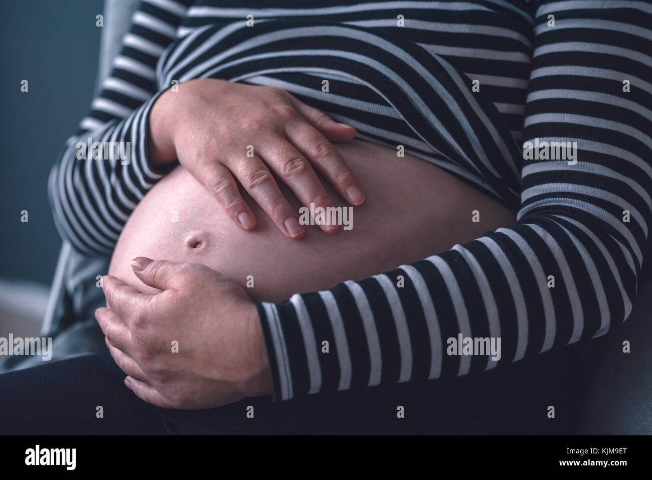 L'amour doux femelle enceinte avec les mains sur son ventre dans le troisième trimestre de la grossesse s'attendant bébé nouveau-né Banque D'Images
