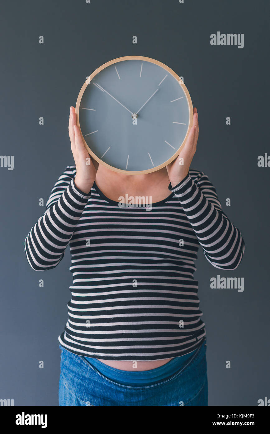 Les femmes enceintes avec vintage réveil attend bébé dans le troisième trimestre de la grossesse Banque D'Images