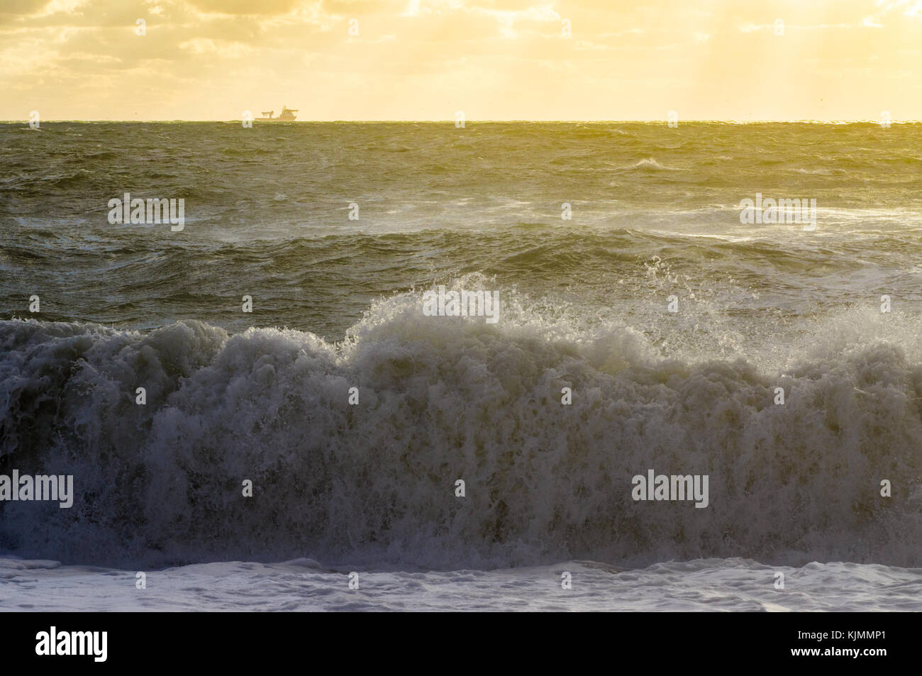 Mer vague sur un coucher du soleil doré et d'expédier à l'horizon Banque D'Images
