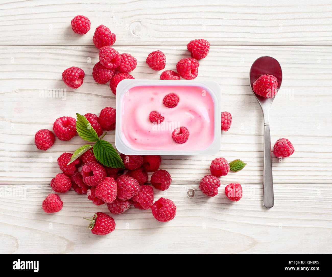 Yaourt framboise dans le bol en plastique table en bois. Yaourt frais. Une alimentation saine notion. haute résolution produit. Vue de dessus Banque D'Images