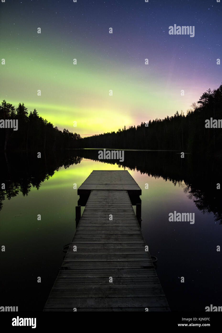 Aurora Borealis pittoresque avec de belles réflexions et jetée de nuit en Finlande Banque D'Images