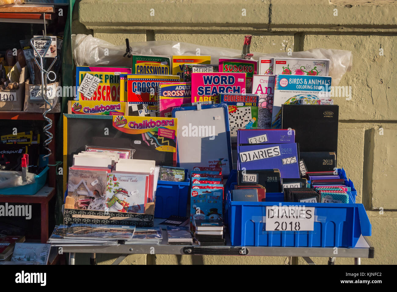 Un affichage en couleur de 2018 journaux intimes, puzzle, calendriers et autres articles de papeterie en plein soleil d'hiver Banque D'Images