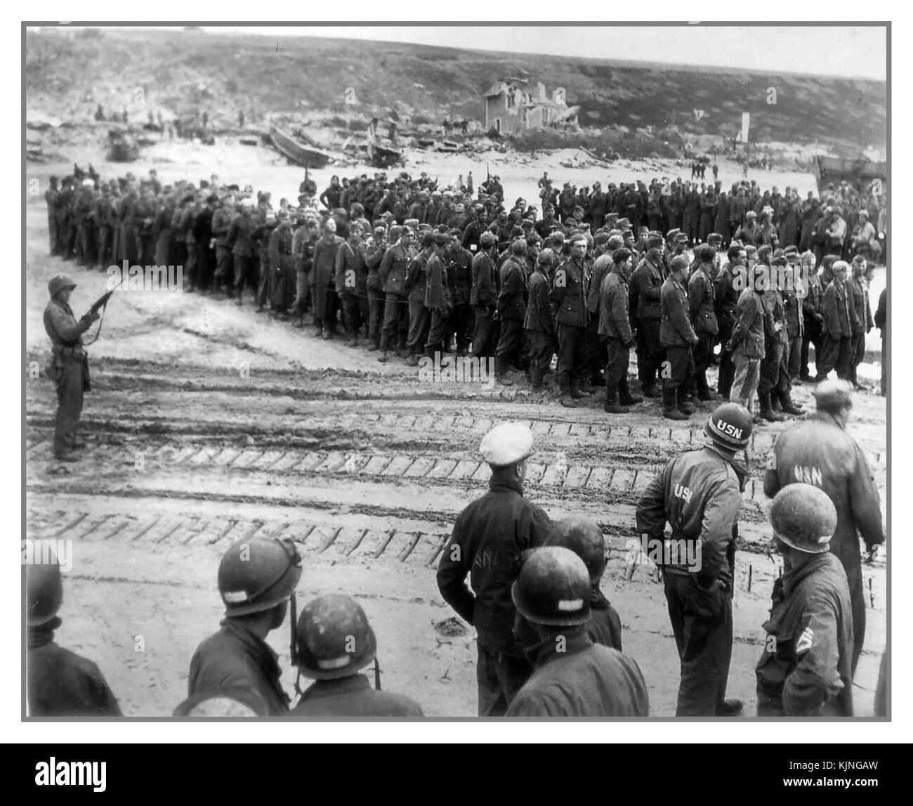 15 juin 1944 Omaha Beach Armée allemande les prisonniers militaires prisonniers de bateau attendent le passage vers le Royaume-Uni... L'Allemagne D-Day et la Wehrmacht Waffen SS prisonniers avec les troupes GI américain garde en premier plan Banque D'Images