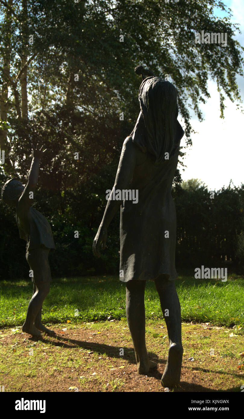 Les graines d'espoir sculpture par Christine Charlesworth, une sculpture en bronze de deux enfants qui jouent. Situé dans l'enceinte de la cathédrale de Guildford. Banque D'Images