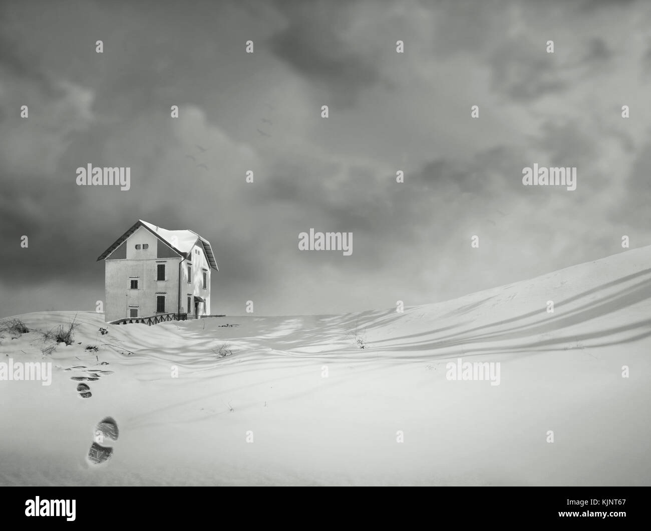 Une maison isolée, dans un merveilleux paysage de neige et ciel dramatique en noir et blanc Banque D'Images