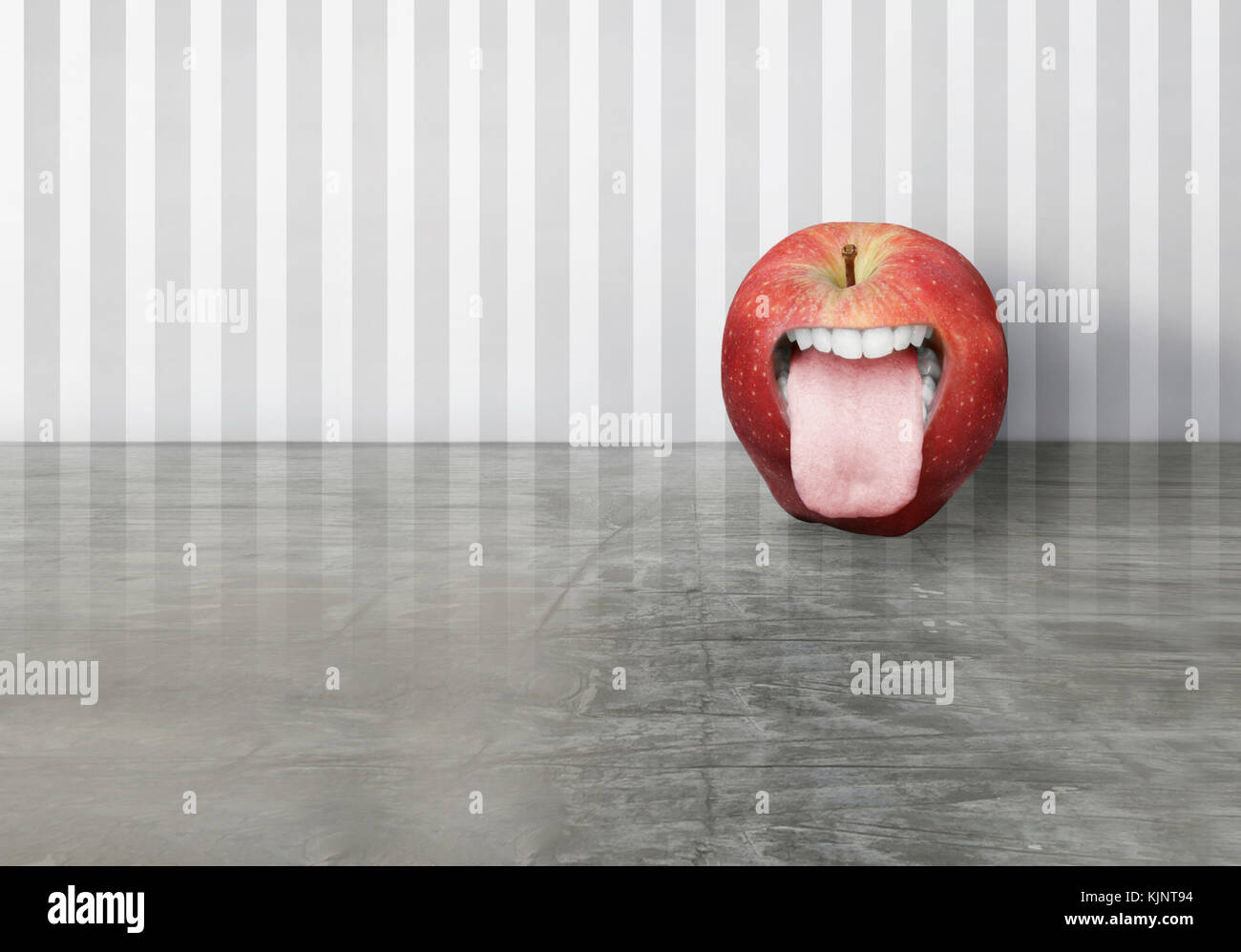 La création artistique d'une pomme rouge avec une bouche humaine ouverte que dans sa langue Banque D'Images