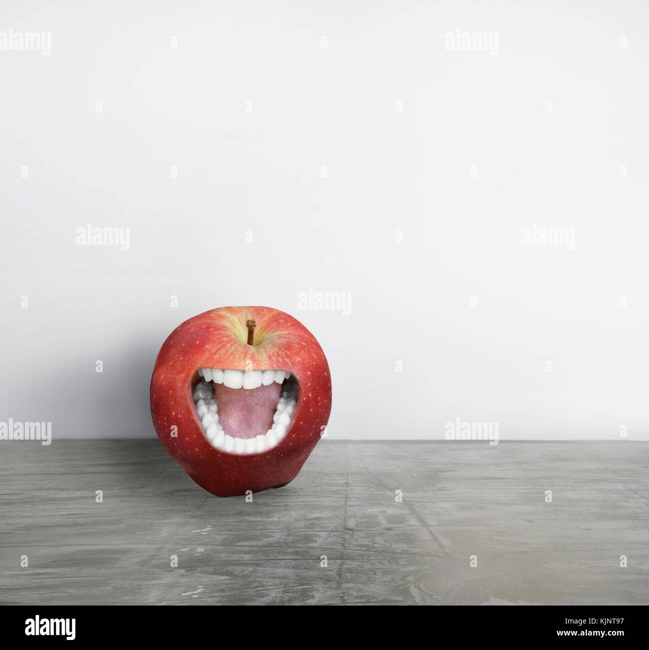 La création artistique d'une pomme rouge avec une bouche humaine que crier Banque D'Images