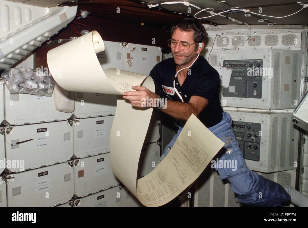 Sts-2 de la nasa navette spatiale columbia premier astronaute de l'équipage se lit vraiment richard alors que le papier de téléimprimeur flottant dans le compartiment intermédiaire de la navette, le 14 novembre 1981 dans l'orbite de la terre. (Photo par joe h. engle via planetpix) Banque D'Images