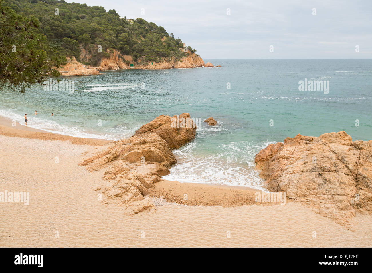 La baie et la plage de Tamariu, Espagne, avec trois nageurs Banque D'Images