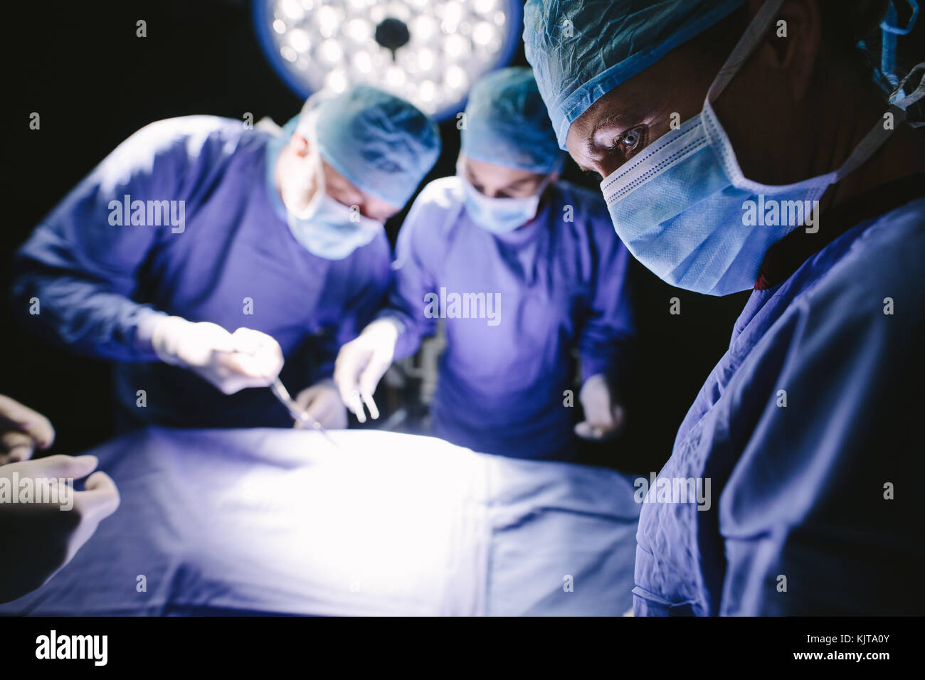 Le port de masque de chirurgien médical avec l'équipe médicale d'effectuer la chirurgie en salle d'opération. Banque D'Images