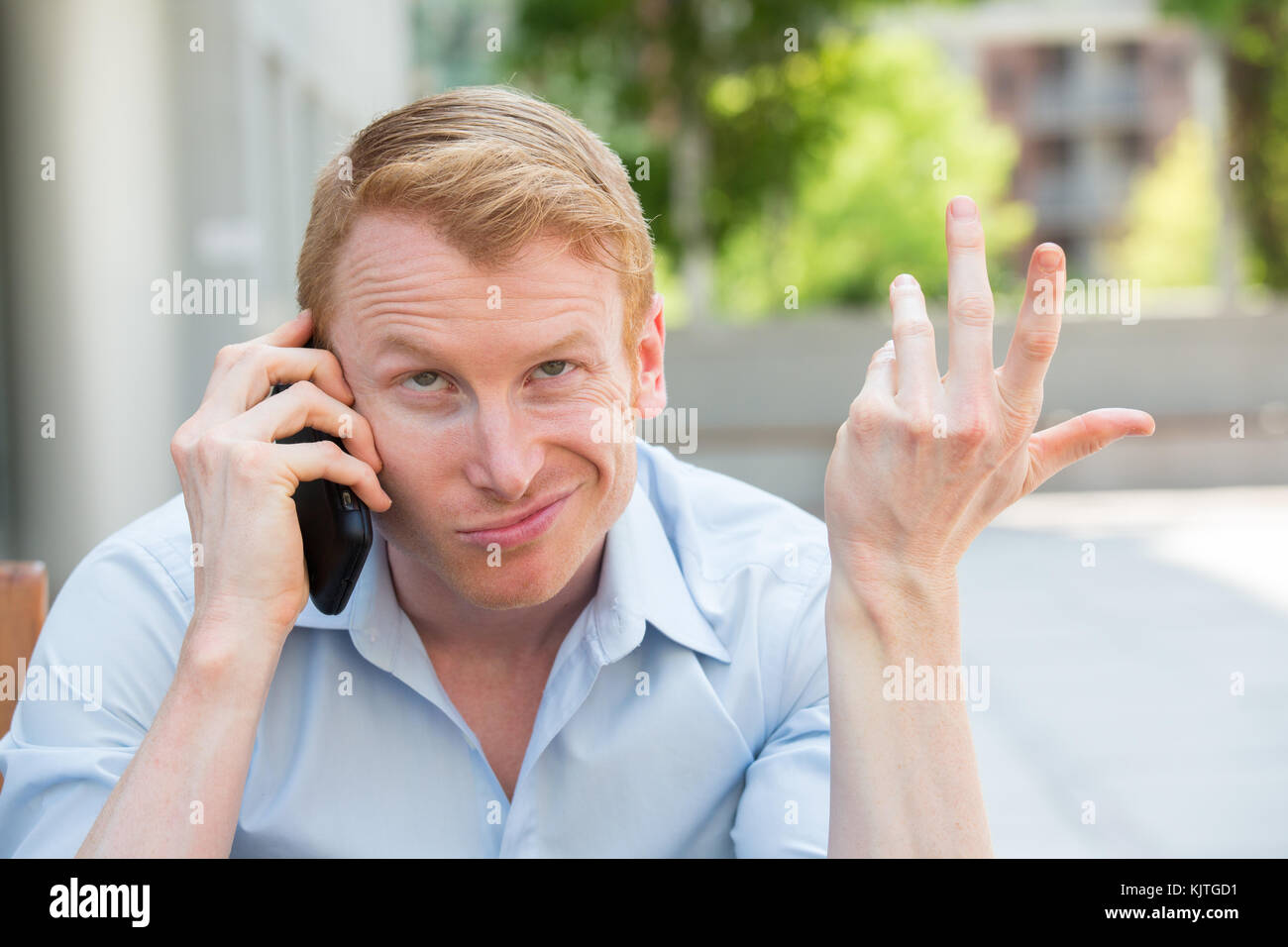Closeup portrait, jeune homme contrarié, frustré, énervé par quelqu'un parler sur son téléphone mobile, de mauvaises nouvelles, isolé à l'extérieur à l'extérieur de l'arrière-plan. lo Banque D'Images