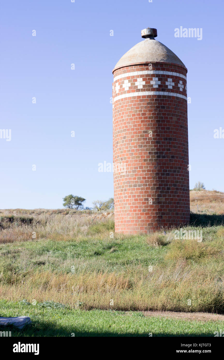 Photo d'un paysage ancien silo à grains en brique rouge dans un champ