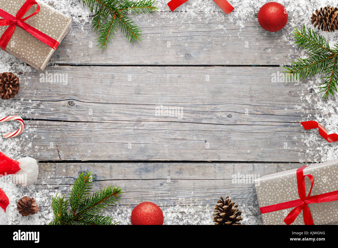 Noël arrière-plan avec copie espace pour le texte. Sapin de noël branches, giftse, sucette, santa hat, pommes et flocons sur table en bois. haut Banque D'Images