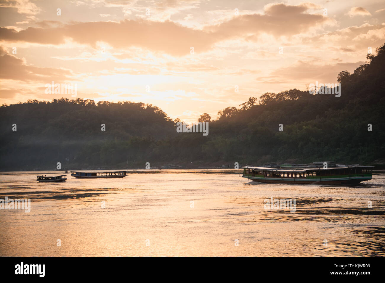 Bateaux de touristes sur le fleuve du Mékong au coucher du soleil à Luang Prabang, Laos Banque D'Images