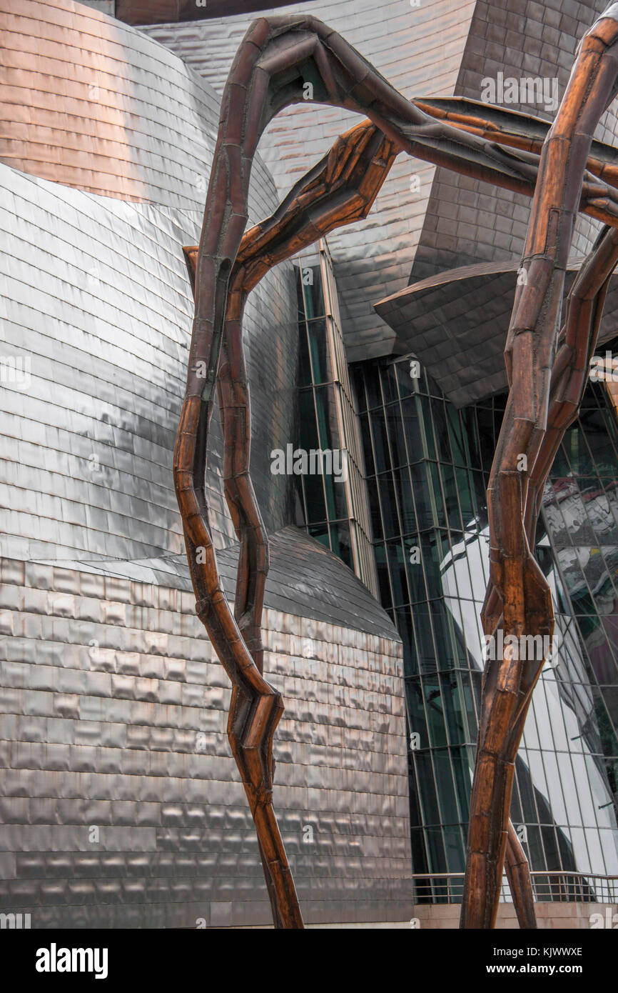 Les jambes d'une araignée géante sculpture contraste avec le revêtement en titane du musée Guggenheim de Bilbao, Espagne Banque D'Images