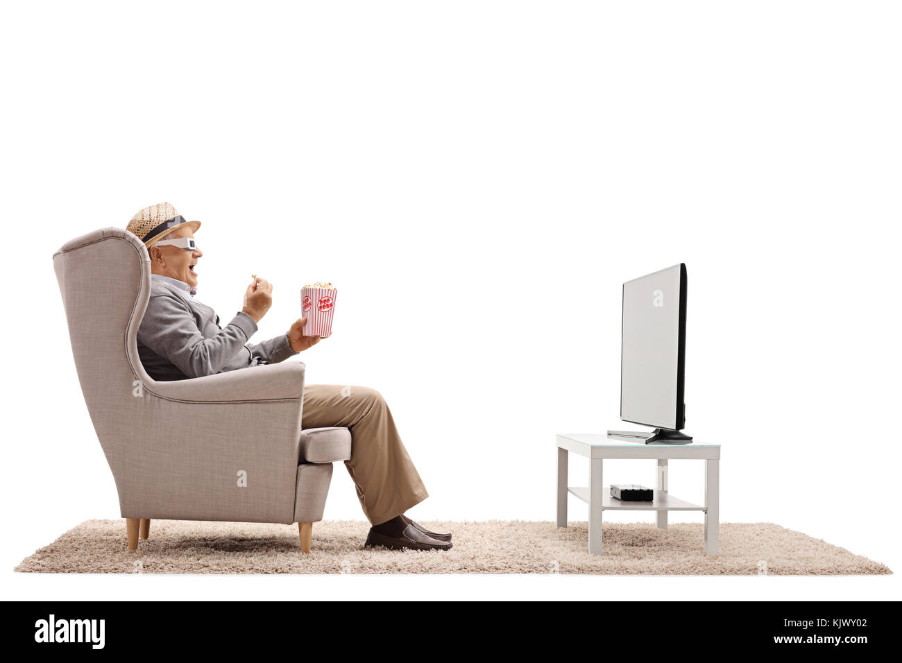 Homme mature avec des lunettes 3-d assis dans un fauteuil eating popcorn et regarder la télévision isolé sur fond blanc Banque D'Images