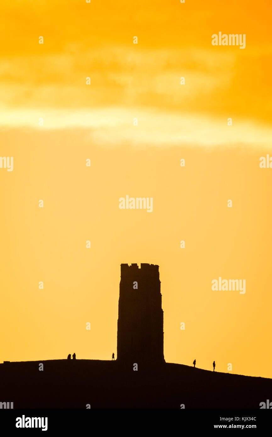 Le soleil se lève derrière la tour St Michael's Tower sur Glastonbury Tor, Somerset, alors que les prévisionnistes ont émis un avertissement météorologique jaune « attention » pour la longueur du côté ouest de la Grande-Bretagne. Banque D'Images