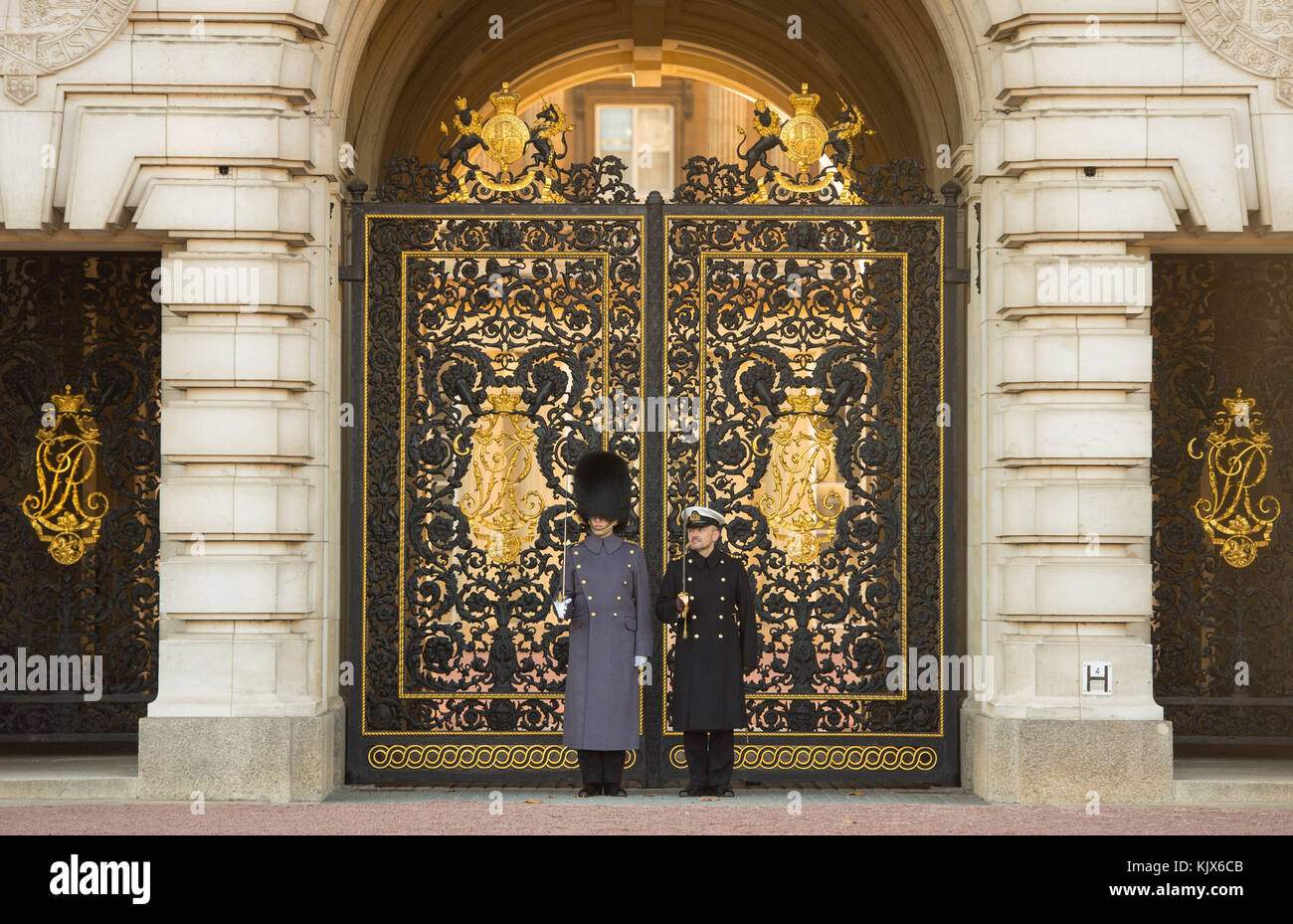 Un officier de la Marine royale (à droite) se tient aux côtés d'un guardman, tandis que des marins de la Marine royale effectuent la cérémonie de la relève de la garde au Palais de Buckingham, à Londres, pour la première fois depuis 357 ans. Banque D'Images