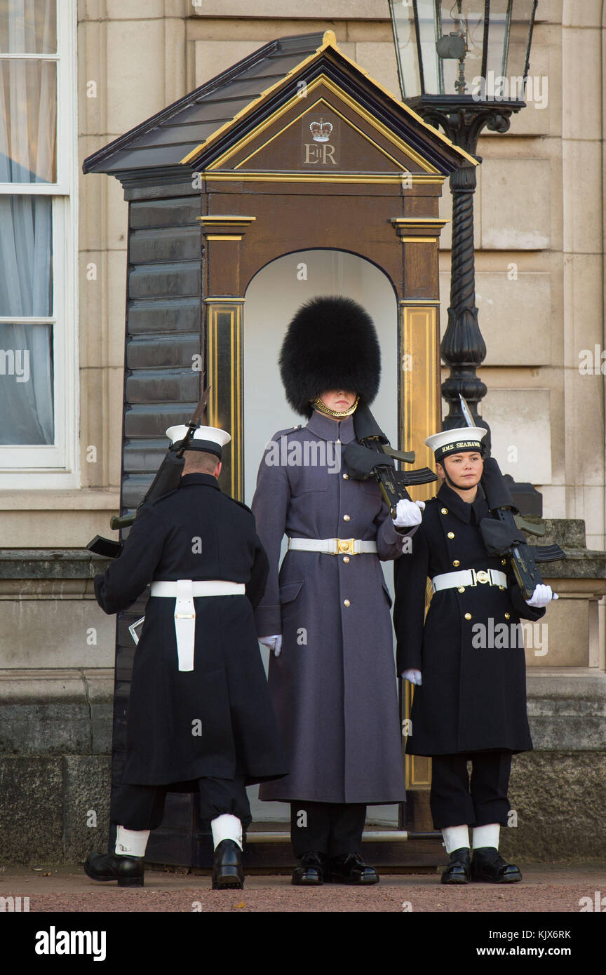 Le couturier Alex Stacey (à droite) prend sa position dans une boîte de sentinelle, alors que des marins de la Royal Navy effectuent la cérémonie de la relève de la garde au Palais de Buckingham, à Londres, pour la première fois dans ses 357 ans d'histoire. Banque D'Images