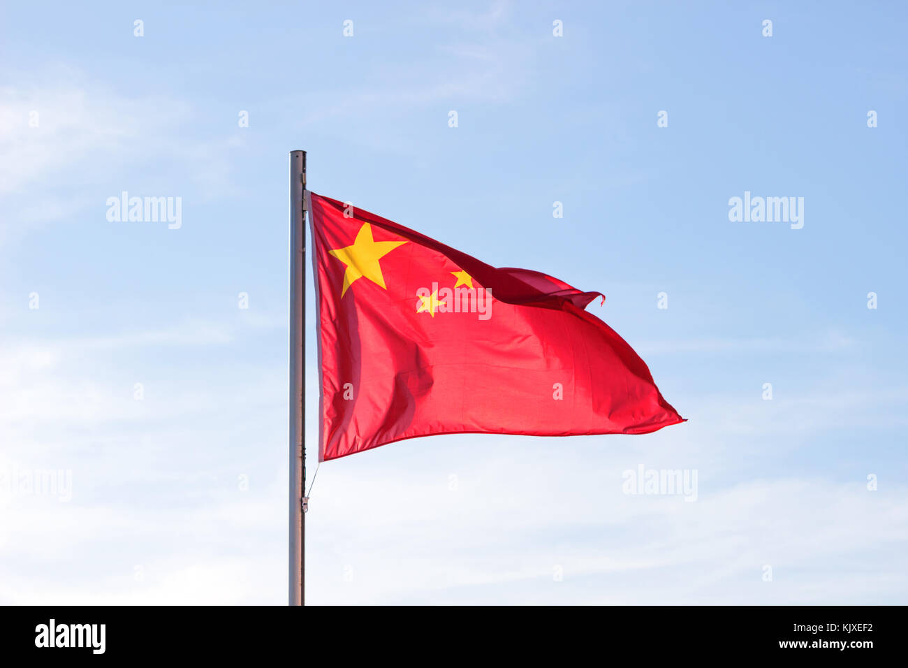 Drapeau chinois en fond de ciel bleu vif, drapeau rouge avec étoile jaune battant en été , vent soufflant du pavillon des ressortissants chinois. Banque D'Images