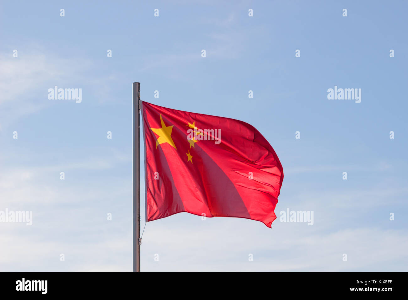 Drapeau chinois en fond de ciel bleu vif, drapeau rouge avec étoile jaune battant en été , vent soufflant du pavillon des ressortissants chinois. Banque D'Images
