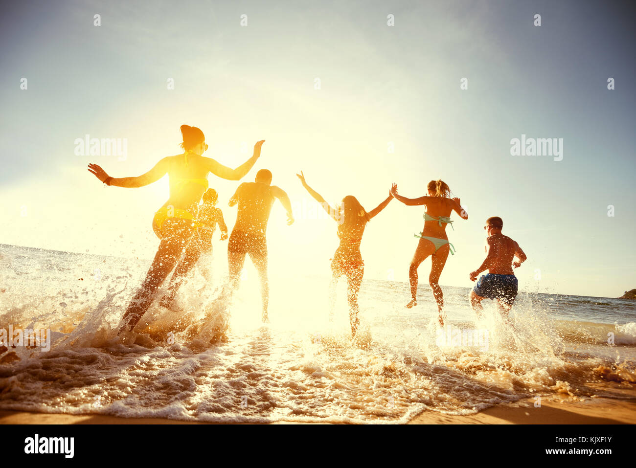 Grand groupe amis coucher de soleil mer plage exécuter Banque D'Images