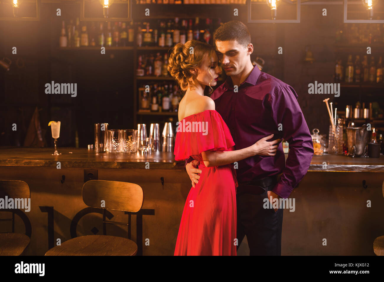 Belle Femme En Robe Rouge Calins Avec Son Homme En Bar Date En Boite De Nuit L Amour En Couple Attrayant Pub Photo Stock Alamy