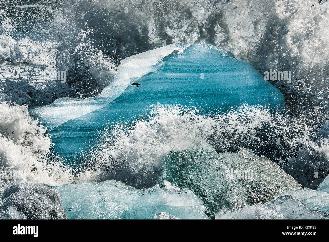 Les vagues crash et créer des gerbes de mousse sur les blocs de glace rejetée sur la plage près de l'Islande, Jokulsarlon Banque D'Images