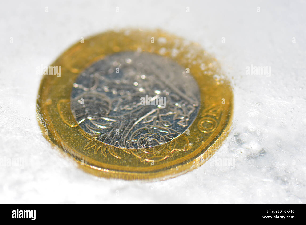 Nouvelle pièce d'une livre pris dans la glace Banque D'Images