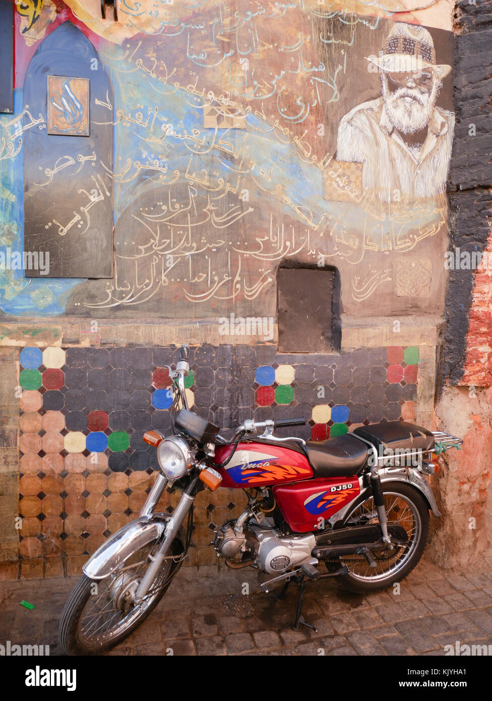 Pour moto garée à côté du mur peint Banque D'Images