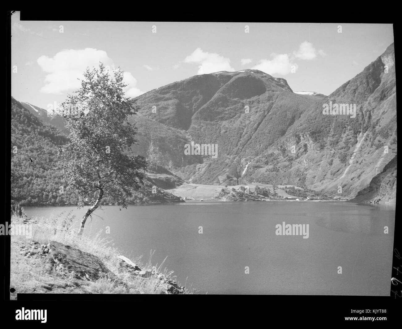 Cette image met en valeur le magnifique paysage de Fretheim, capturé dans une photographie du 25 mars 2015. La scène comprend des fjords, des montagnes et des structures villageoises norvégiennes traditionnelles, mettant l'accent sur la beauté naturelle et le patrimoine culturel de la région. Banque D'Images