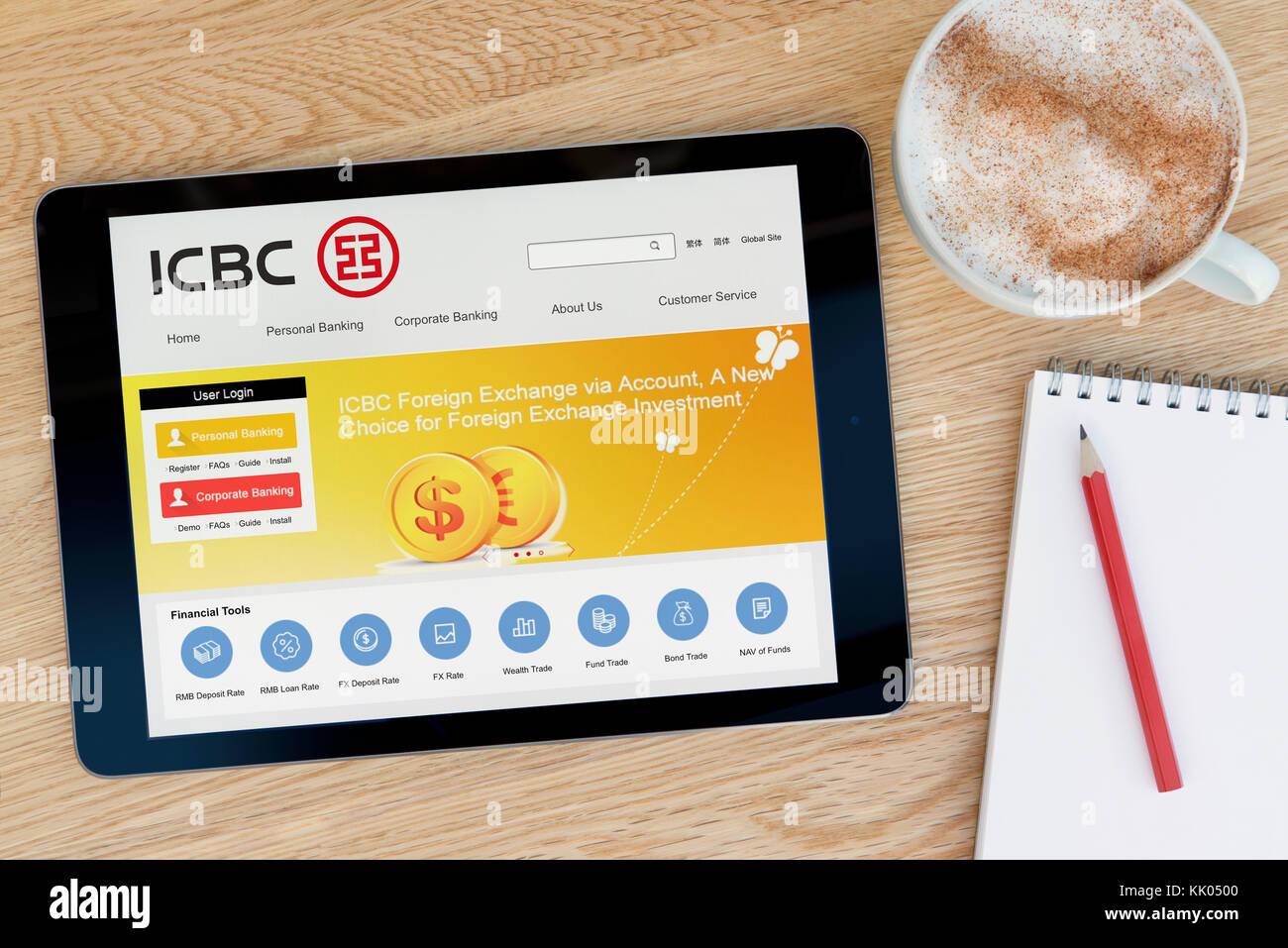 Un homme regarde le site web de la banque ICBC sur son iPad tablet device, tourné contre une table en bois page contexte (usage éditorial uniquement) Banque D'Images