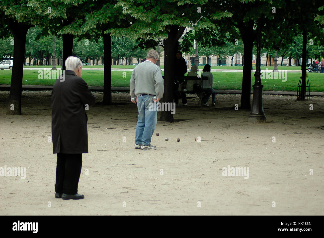 Les hommes âgés dans un parc public à Paris lors d'une partie de pétanque jeter la metal europeen pour les obtenir le plus près possible de balle en bois appelé jack Banque D'Images