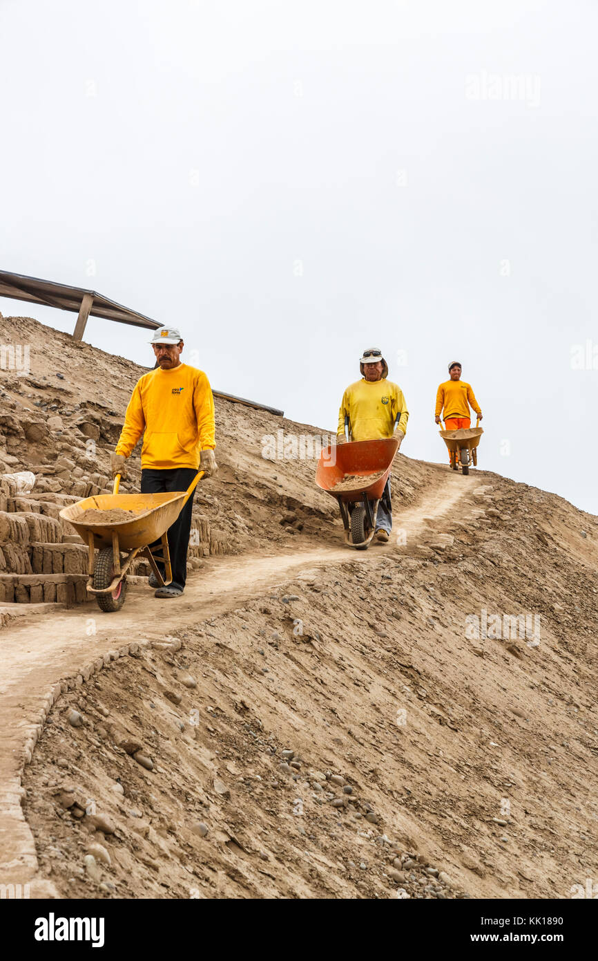 Trois ouvriers péruviens locaux avec des brouettes de travailler sur la restauration de la ruines pré-Inca à Huaca Pucllana ou Huaca Juliana, Miraflores, Lima, Pérou Banque D'Images